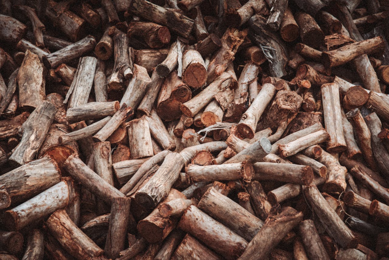 A large pile of cut firewood logs with a rustic texture, ideal for winter heating.